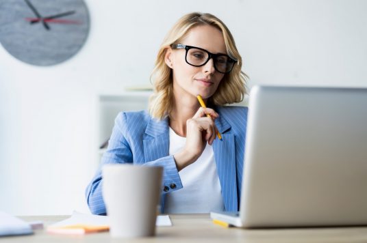 woman reviewing forms wearing blue woman reviewing forms wearing blue
